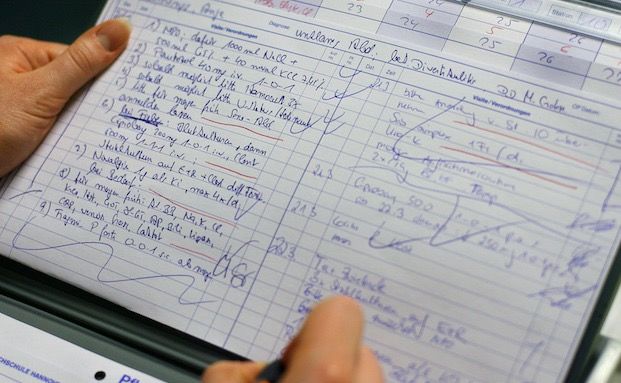 Ein Mann schreibt Notizen auf ein Blatt