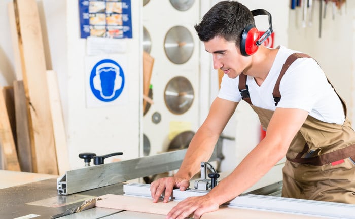 Zimmermann schneidet Holzplanke