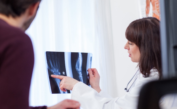 Eine Ärztin zeigt einem Patienten sein Röntgenbild