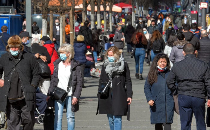Menschen mit Gesichtsmasken in Zeiten der Corona-Pandemie auf der Straße in Berlin