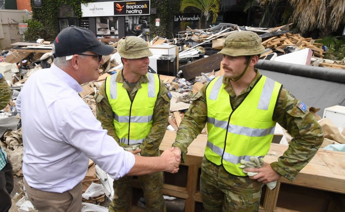 Australiens Premierminister Scott Morrison spricht mit Helfern in der Katastrophenregion nahe der Stadt Brisbane.