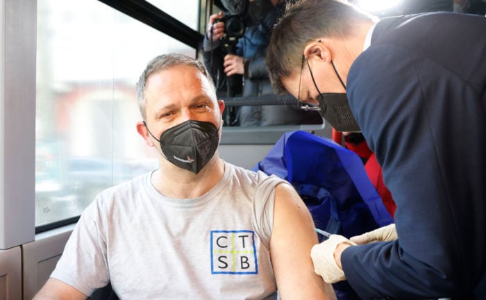 Bundesgesundheitsminister Karl Lauterbach (rechts) impft einen Mann im Tour-Bus der Initiative #ImpfenHilft.