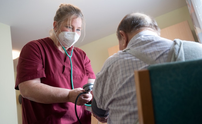 Pflegekraft misst Blutdruck eines Patienten