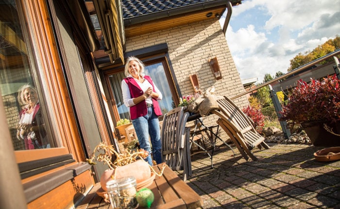 Ältere Dame mit Einfamilienhaus