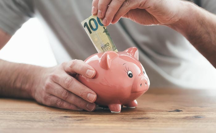 Mann füttert sein Sparschwein