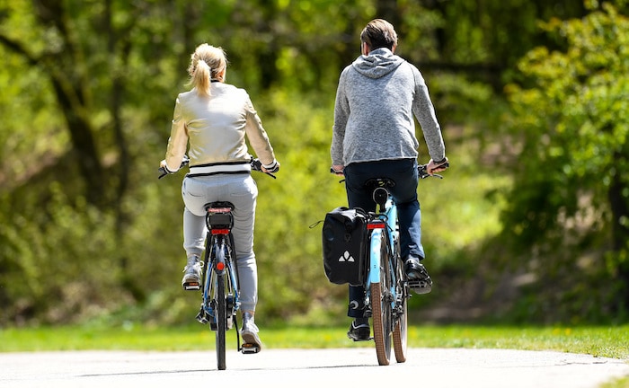 Ein Paar fährt mit E-Bikes auch einen Park