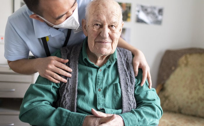Altenpfleger redet mit einem Bewohner im Pflegeheim