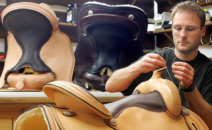 Ein Sattler fertigt einen Sattel an