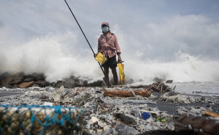 Fischer in Sri Lanka an einem mit Plastik-Pellets verseuchten Strand
