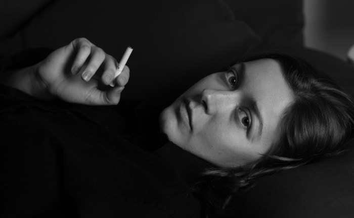 Frau mit Zigarette: Es ist üblich geworden, dass Raucher bei Risikolebensversicherungen in Nichtrauchertarife wechseln können, wenn sie aufgehört haben