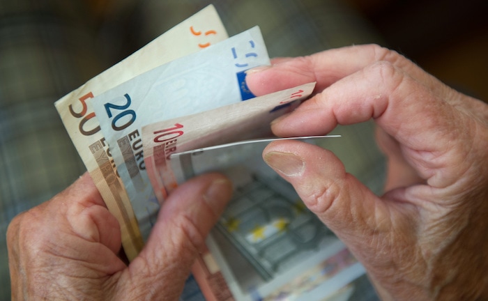 Rentner zählt Geldscheine