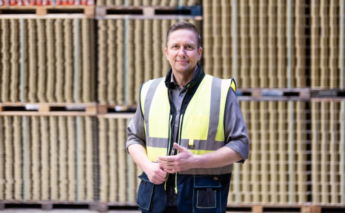 Werner Hansen, Commercial Direktor bei der Dosenzentrale, vor leeren Konservendosen