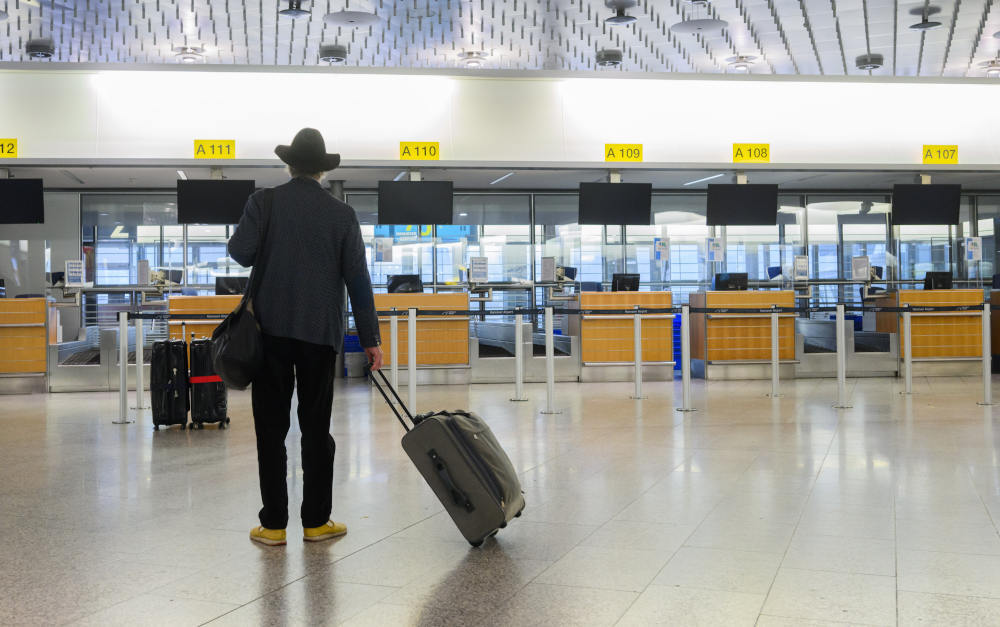 Fluggast am Flughafen Hannover vor leeren Check-In-Schaltern am 17. Februar