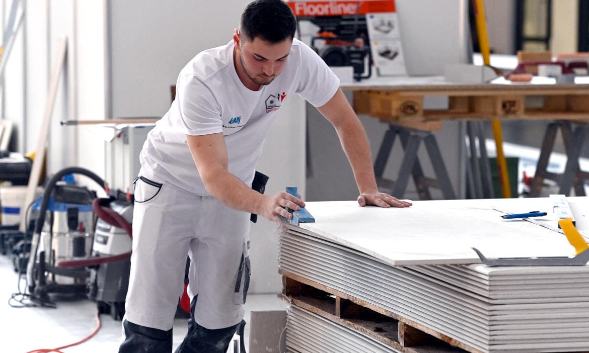 Lehrling schneidet Platten aus Gipskarton: Azubis sind eine neue wichtige Zielgruppe für die Anbieter von Berufsunfähigkeitsversicherungen