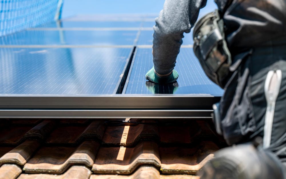 Arbeiter bauen eine Photovoltaikanlage aufs Dach