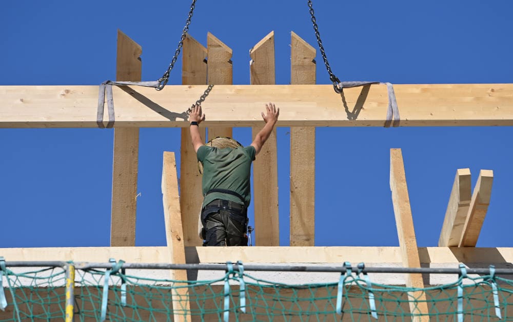 Zimmermann auf der Baustelle: Materialpreise und Löhne fließen in den Anpassungsfaktor mit ein