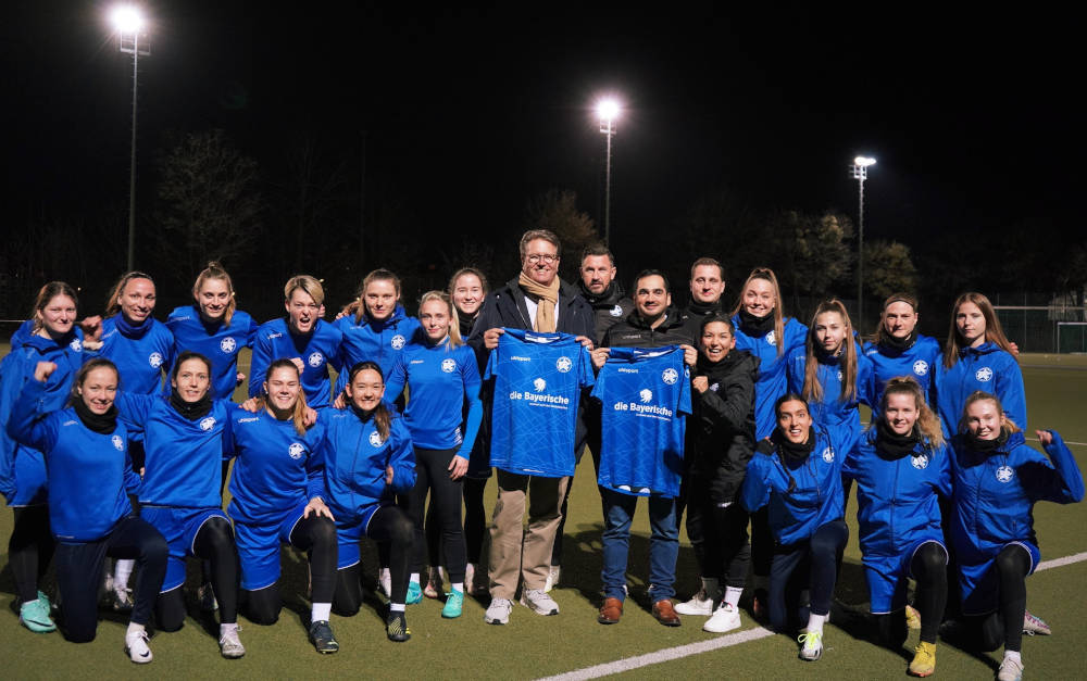 Martin Gräfer (Mitte links), Vorstand der Bayerischen, und Salih Aydogan, Präsident des FFC Wacker München, mit der 1. Mannschaft des FFC Wacker München.