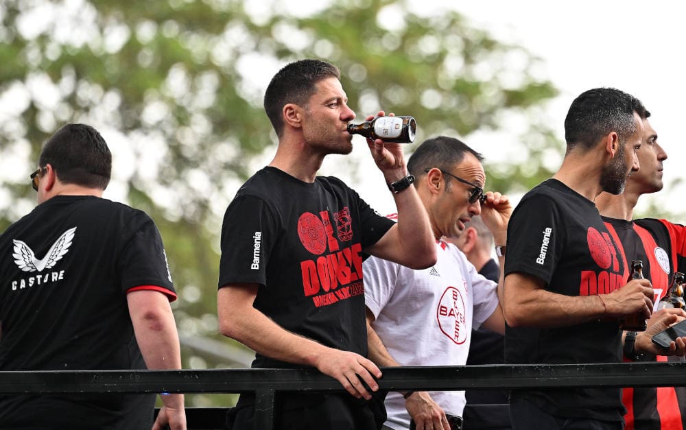Mit Bier und Barmenia: Leverkusens Trainer Xabi Alonso (2.v.l) nach dem Gewinn des DFB-Pokals im Autokorso