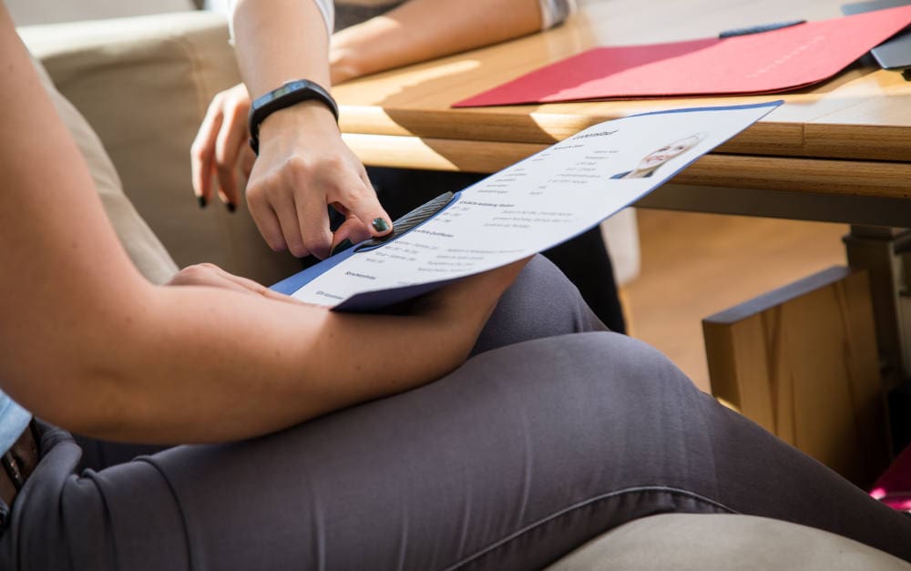 Frau mit Bewerbungsunterlagen: bAV wird in der Jobwelt zum Hygienefaktor