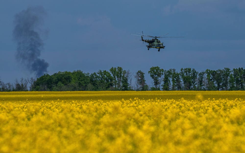 Ukrainischer Kampfhubschrauber über einem Feld: Kriegsrisikoversicherungen für die Landwirtschaft