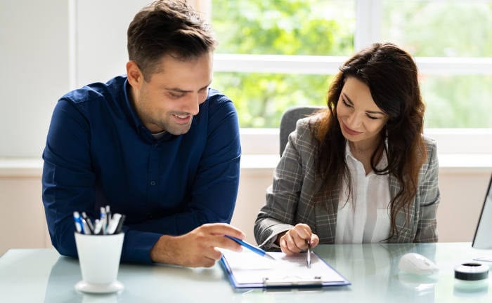 Junges Paar sitzt an einem Tisch und geht einen Vertrag durch