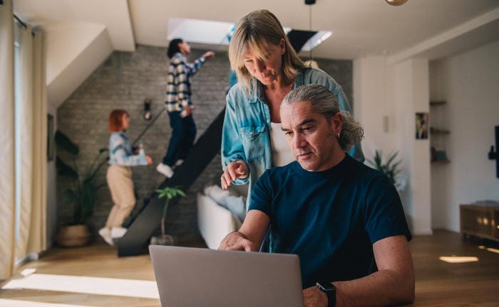 Ehepaar am Laptop in ihrem Wohnzimmer