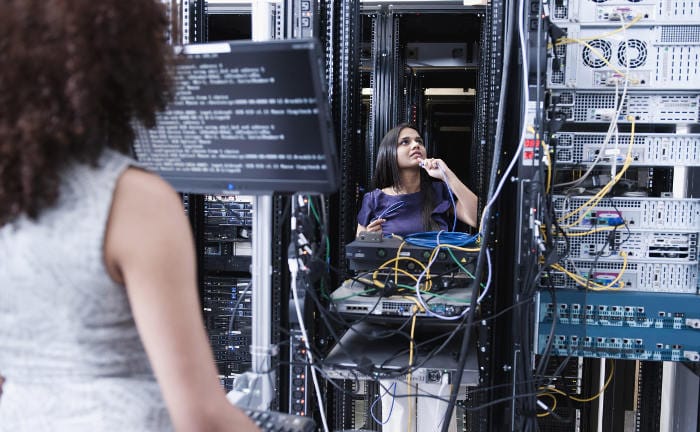 Zwei Frauen arbeiten in einem Serverraum: Die NIS-2-Richtlinie verpflichtet Firmen dazu, ihre IT sicherer zu machen gegen Cyberangriffe.