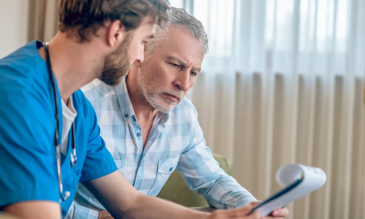 Arzt mit Patient: Heilberufler sehen sich vielen Risiken gegenüber. Arzt oder Ärztin brauchen daher einen entsprechend starken Versicherungsschutz.