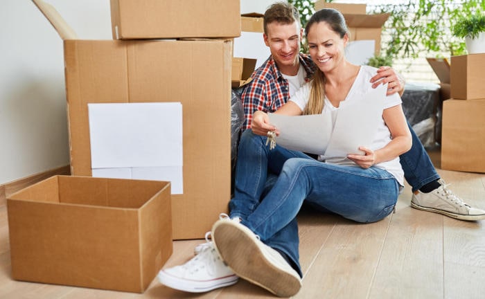 Junges Paar sitzt zwischen Umzugskisten: Das Eigenheim bleibt für viele Deutsche ein Traum, den sie sich gerne erfüllen möchten.