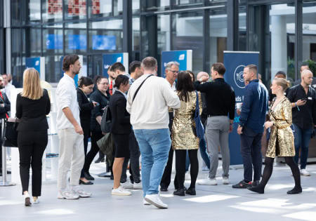 Besucher halten sich im Eingangsbereich der Messe auf. Foto: Fonds Finanz
