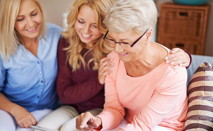 Großmutter und Enkelkind schauen auf ein Tablet und planen Schenkungen im Rahmen der Ruhestandsplanung.
