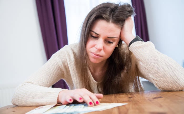 Frau, die traurig über Anlagefehler nachdenkt: Fehler in der Geldanlage passieren allen Anlegerinnen und Anlegern.