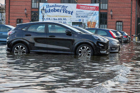 Autos stehen am überfluteten Fischmarkt in Hamburg: Es ist gefährlich, mit dem Auto durch überspülte Straßen zu fahren. Foto: picture alliance/dpa | Georg Wendt