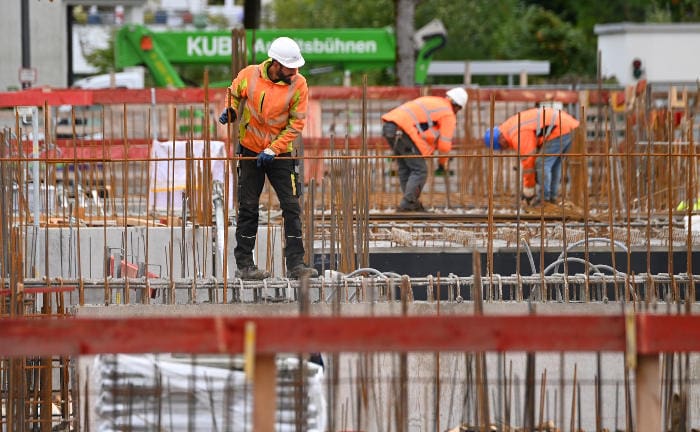 Handwerker bauen den Rohbau eines Hauses: Zusatzleistungen wie die Koordination von Handwerkern wünschen sich Versicherte von ihren Versicherern.