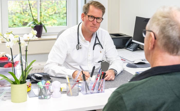 Hausarzt berät einen Patienten: Die Zusatzbeiträge der gesetzlichen Krankenkassen werden 2025 weiter steigen.