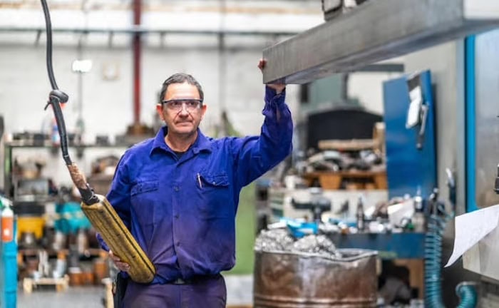 Fabrikarbeiter bedient eine Maschine in einer Halle: Unternehmen benötigen Industriemakler mit guten Datenanalysen.