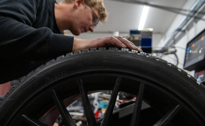 Automechaniker führt einen Reifenwechsel durch: Schlechte Nachrichten für KFZ-Versicherer und ihre Kunden: Die Dienstleistungen in Autowerkstätten werden teurer.