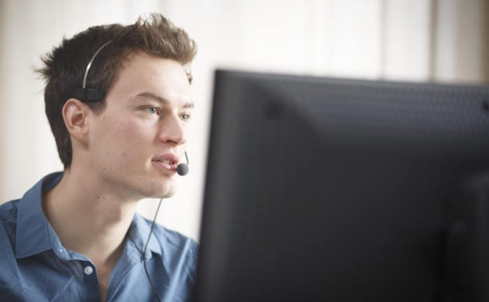 Service-Mitarbeiter sitzt vor einem PC und telefoniert mit einem Kunden: Die Servicequalität von Insurtechs hat sich verbessert.