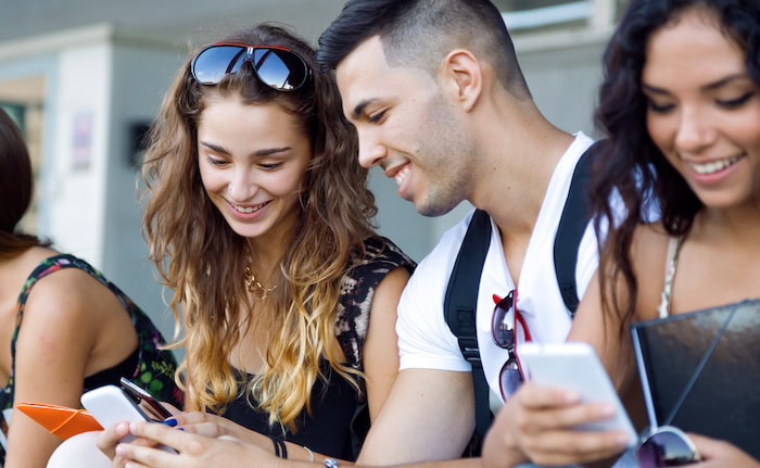 Junge Leute am Handy: Für viele junge Menschen ist Altersvorsorge noch kein Thema.