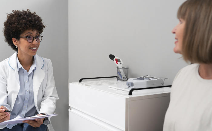 Ärztin spricht im Sprechzimmer mit Patientin: Die höhere Jahresarbeitsentgeltgrenze sorgt dafür, dass weniger Angestellte in die PKV wechseln können.