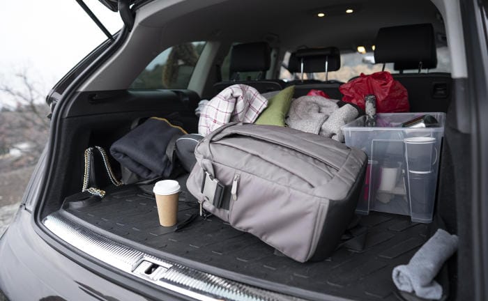 Offener Kofferraum eines Autos mit Wertgegenständen: Um Diebstähle zu vermeiden, sollten Versicherte darauf achten, Wertgegenstände nicht im geparkten Auto zu lassen.