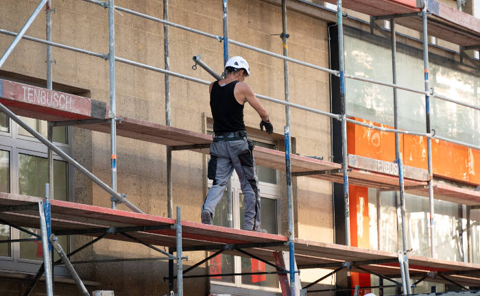Gerüstbauer mit Balken: Für Gerüstbauer ist es teuer, eine BU-Versicherung abzuschließen.