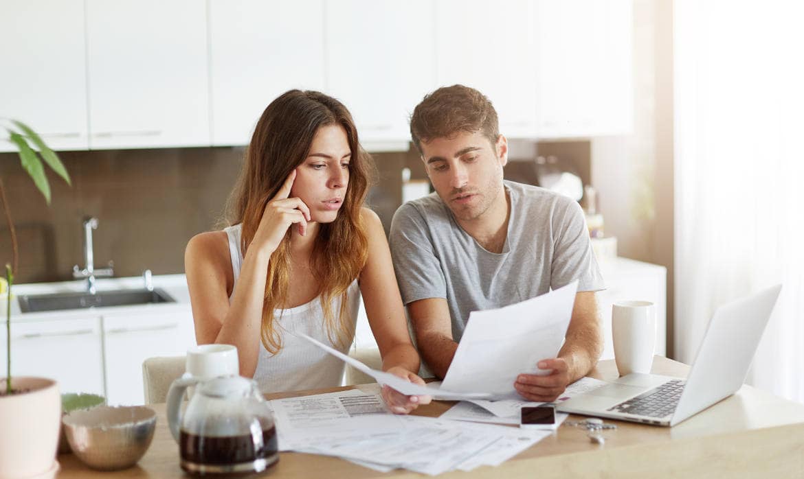 Junges Paar füllt zusammen eine Steuererklärung aus: Auch für die Steuererklärung im Jahr 2024 können Steuerpflichtige noch durch bestimmte Tipps Steuern sparen.