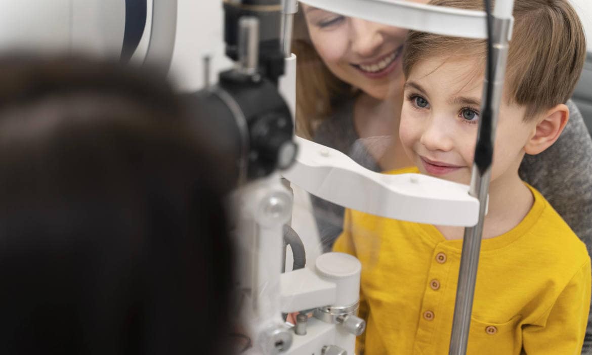 Kind beim Optiker: Die richtige Krankenzusatzversicherung zahlt auch für Sehhilfen wie zum Beispiel die Brille