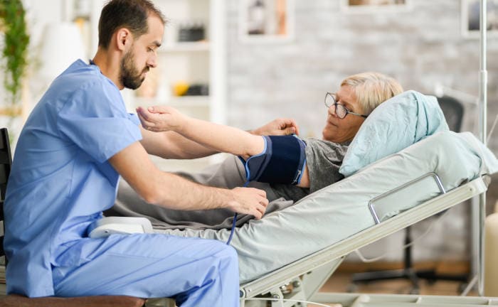 Krankenpfleger behandelt eine Patientin: Finanziell rechnen sich PKV-Versicherte für Ärzte mehr als gesetzlich Versicherte.