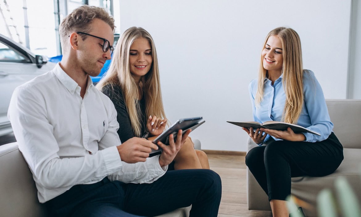 Maklerin berät junges Ehepaar: Makler möchten lieber unabhängige Maklerpools, hat Servicevalue herausgefunden.