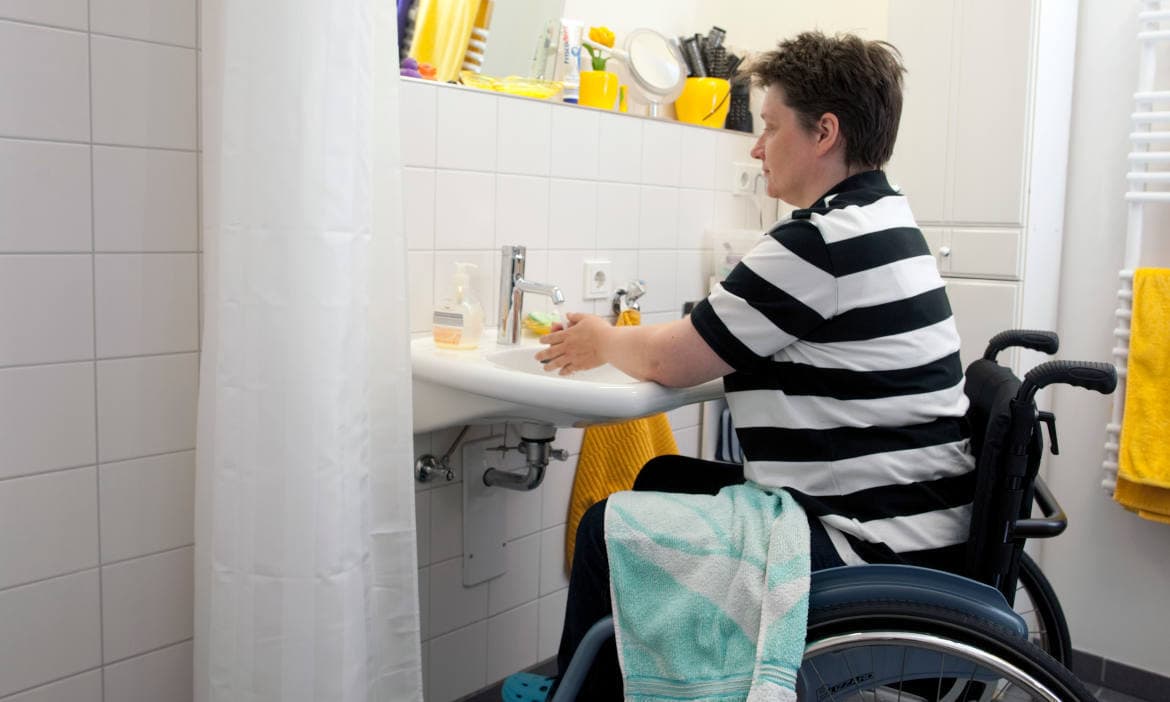 Rollstuhlfahrerin in behindertengerechter Wohnung: Die Unfallkosten-Versicherung bezahlt den Umbau