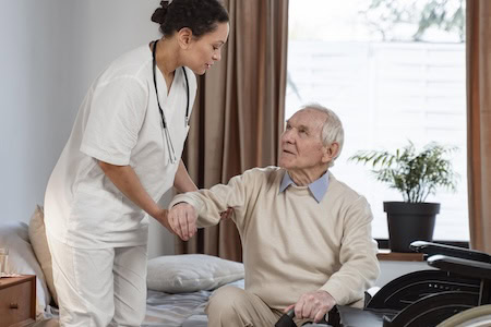 Pflegerin hilft mann im Rollstuhl Foto: Freepik