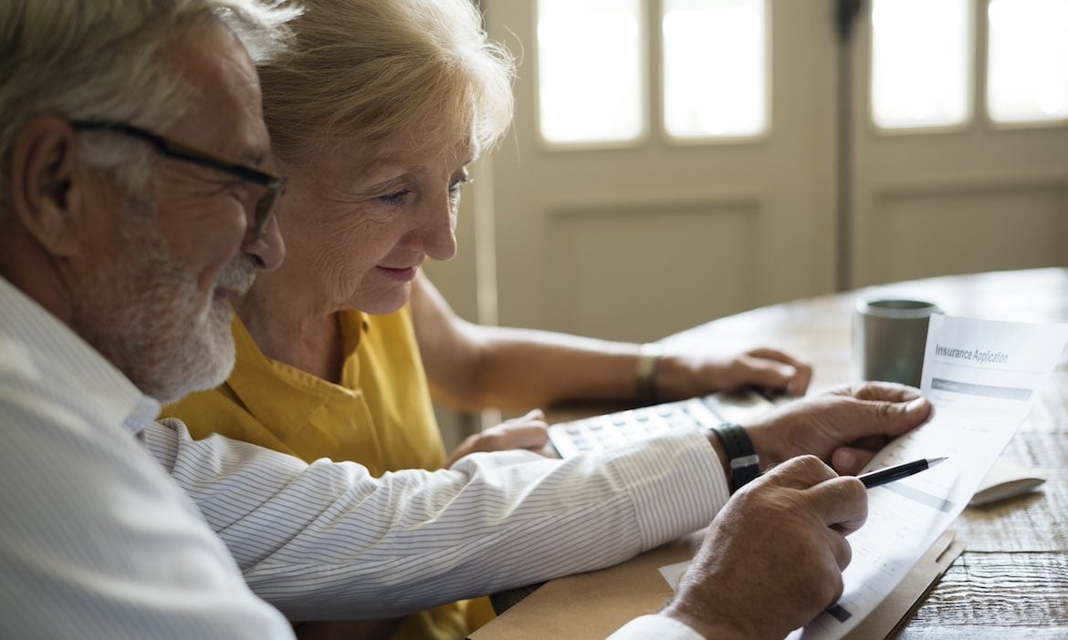 Senioren schauen auf Versicherungsvertrag: Die Überschussbeteiligung der deutschen Lebensversicherer steigt.