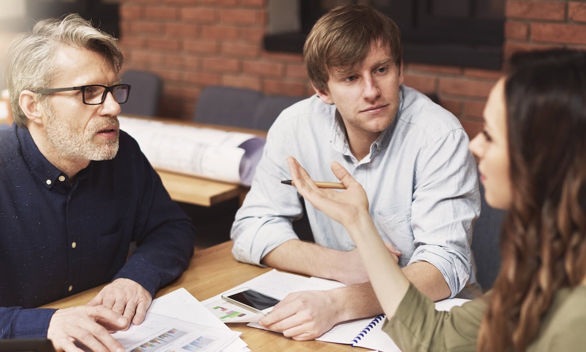 3 Menschen diskutieren an einem Tisch: Im JAhr 2024 kam es zu mehr Beschwerden bei der Versicherungsombudsstelle, vor allem bei KFZ-Versicherungen.